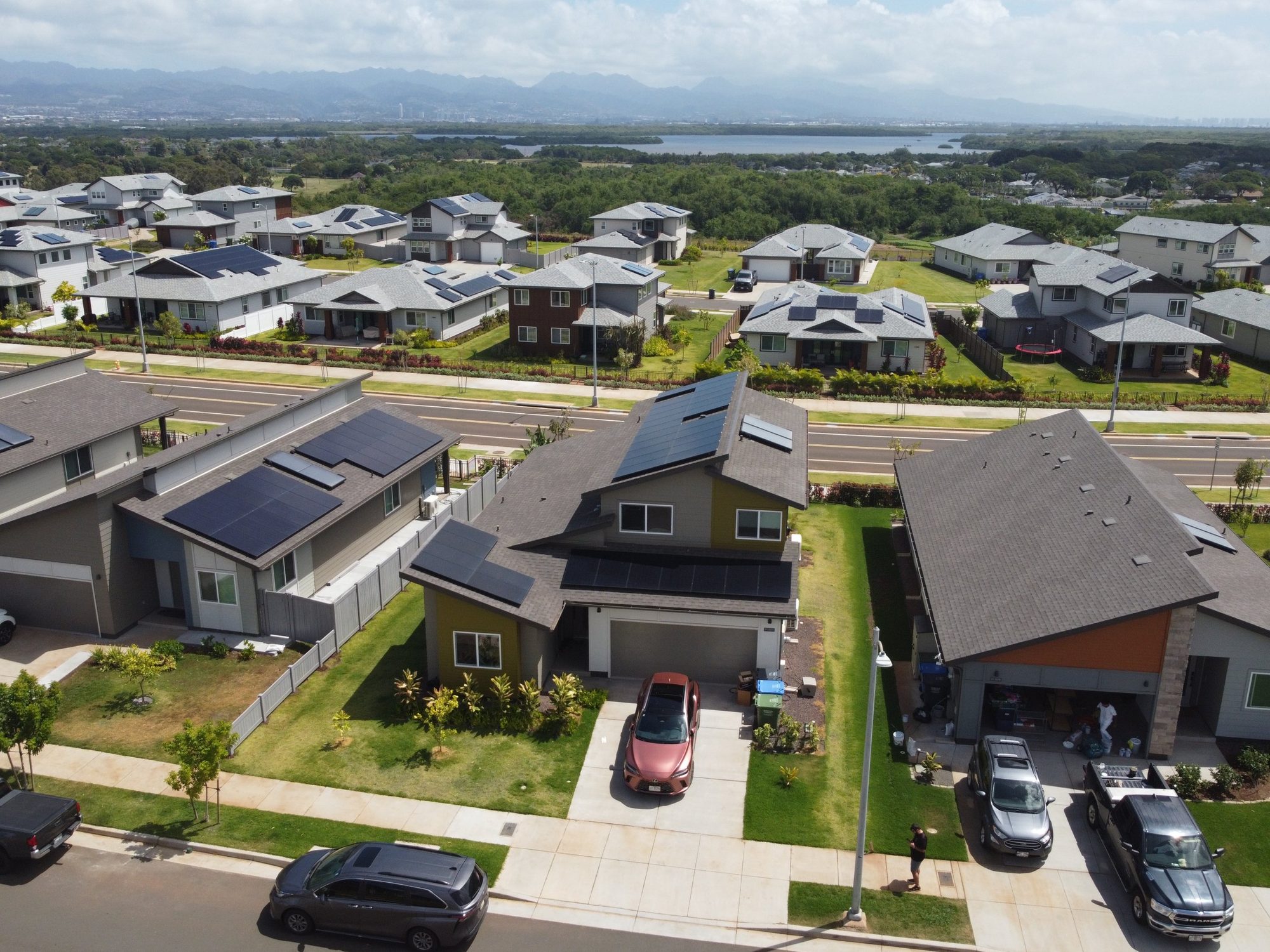 Drone view of a solar-powered Oahu neighborhood looking toward Pearl Harbor and the Koolau mountains